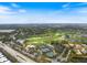 High aerial view showcases tennis and golf near the community, with roads and lush trees at 72 Grande Fairway, Englewood, FL 34223