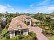 An aerial view of the home showing the surrounding landscaping, roof, and brick driveway at 72 Grande Fairway, Englewood, FL 34223