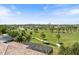 Scenic aerial view showcasing lush golf course, mature trees, and tile roofs under a clear blue sky at 72 Grande Fairway, Englewood, FL 34223