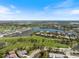 Expansive aerial view featuring a community with multiple lakes, a golf course, and residential homes under blue skies at 72 Grande Fairway, Englewood, FL 34223