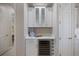 Convenient wet bar with white cabinets, quartz counters, wine fridge, and glass front display cabinets at 72 Grande Fairway, Englewood, FL 34223