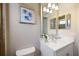 Elegant bathroom with a framed mirror, white vanity, and stylish decor creating a serene and modern space at 72 Grande Fairway, Englewood, FL 34223
