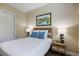 Bedroom with art, lamps on bedside tables, ceiling fan, closet and blue throw pillows at 72 Grande Fairway, Englewood, FL 34223
