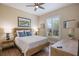 Cozy bedroom with natural light, wooden furniture, and serene decor with a ceiling fan at 72 Grande Fairway, Englewood, FL 34223