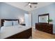 Comfortable bedroom with ceiling fan, dresser, mirror, closet and hardwood floors at 72 Grande Fairway, Englewood, FL 34223