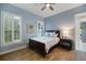 Bedroom featuring a window with plantation shutters, ceiling fan, side table and dark furniture at 72 Grande Fairway, Englewood, FL 34223