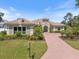 Beautiful home featuring a tiled roof, well-manicured landscaping, and a brick driveway at 72 Grande Fairway, Englewood, FL 34223