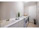 Bright laundry room features a utility sink, white cabinets, and modern washer and dryer for convenient chores at 72 Grande Fairway, Englewood, FL 34223