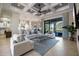 Bright living room boasts coffered ceilings, a ceiling fan, and a sliding glass door to the outdoors at 72 Grande Fairway, Englewood, FL 34223