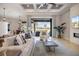 Bright living room with a coffered ceiling, stone fireplace, and sliding glass doors to the outdoor area at 72 Grande Fairway, Englewood, FL 34223
