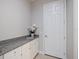 Mudroom with white cabinets, granite countertops, and neutral wall color near a door at 72 Grande Fairway, Englewood, FL 34223