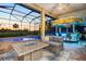 Relaxing outdoor patio with a tiki bar, fire table, and comfortable seating overlooking a sparkling pool at 72 Grande Fairway, Englewood, FL 34223