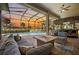 Inviting outdoor living area with a screened pool, spa, and tiki bar at sunset at 72 Grande Fairway, Englewood, FL 34223