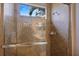 Tiled shower with glass doors and window offers a refreshing and bright space in the well-appointed bathroom at 72 Grande Fairway, Englewood, FL 34223