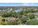 Expansive aerial view of a home nestled among lush trees and overlooking a serene lake in a tranquil neighborhood at 7602 Partridge Street Cir, Bradenton, FL 34202