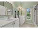 Bright bathroom boasts dual sinks, modern fixtures, and a window with backyard views at 7602 Partridge Street Cir, Bradenton, FL 34202