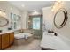 Bathroom featuring a garden tub, tiled shower, dual sinks, and shuttered window at 7602 Partridge Street Cir, Bradenton, FL 34202