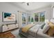Bright bedroom boasts tray ceilings, wood floors, and sunny windows with backyard views and access to the pool deck at 7602 Partridge Street Cir, Bradenton, FL 34202