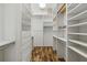 Walk-in closet provides ample storage with custom shelving, drawers, and wood floors at 7602 Partridge Street Cir, Bradenton, FL 34202