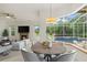 Charming dining area adjacent to the living room, featuring a modern light fixture and views of the pool at 7602 Partridge Street Cir, Bradenton, FL 34202
