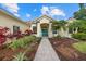 Inviting home exterior with landscaped front yard, stone walkway, and a bright blue door at 7602 Partridge Street Cir, Bradenton, FL 34202