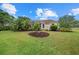 Beautifully landscaped exterior with green grass, mature trees, and vibrant flowerbeds at 7602 Partridge Street Cir, Bradenton, FL 34202