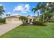Charming single-story home featuring a three-car garage, a colorful front garden, and a well-manicured lawn at 7602 Partridge Street Cir, Bradenton, FL 34202