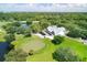 Aerial shot of golf course with clubhouse, putting green, and surrounding trees at 7602 Partridge Street Cir, Bradenton, FL 34202