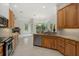 Kitchen features granite countertops, stainless steel appliances, wood cabinets, and views of the fireplace at 7602 Partridge Street Cir, Bradenton, FL 34202