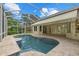 A refreshing screened-in pool features a travertine deck and covered patio at 7602 Partridge Street Cir, Bradenton, FL 34202