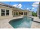 A refreshing screened-in pool features a travertine deck and covered patio at 7602 Partridge Street Cir, Bradenton, FL 34202