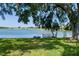 Picturesque view of the lake from the backyard, accentuated by mature trees and a private dock at 8467 Imperial Cir, Palmetto, FL 34221