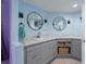 This bathroom features a gray cabinet, white countertop, dual vanity, and blue walls at 8467 Imperial Cir, Palmetto, FL 34221