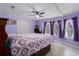 This is a bedroom with purple walls, tile flooring, and a ceiling fan at 8467 Imperial Cir, Palmetto, FL 34221