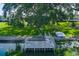 Charming waterfront scene featuring a private dock and boat, surrounded by lush trees and greenery at 8467 Imperial Cir, Palmetto, FL 34221