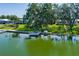 Idyllic waterfront setting with a private dock, shaded by mature trees and surrounded by green lawns at 8467 Imperial Cir, Palmetto, FL 34221