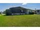 A home with a large screened-in porch, showcasing a well-maintained lawn and established landscaping at 8467 Imperial Cir, Palmetto, FL 34221
