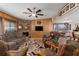 Inviting living room featuring a decorative fireplace, wood paneling, and comfortable seating at 8467 Imperial Cir, Palmetto, FL 34221