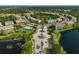 Aerial of a residential area featuring community pool, pond, and mature trees at 8827 White Sage Loop, Lakewood Ranch, FL 34202