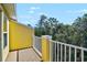 View of the treeline from the balcony with white railings and yellow exterior walls at 8827 White Sage Loop, Lakewood Ranch, FL 34202