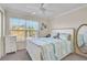 Cozy bedroom with a queen bed, ceiling fan, and large window with blinds at 8827 White Sage Loop, Lakewood Ranch, FL 34202
