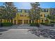 Charming yellow townhouse featuring well-maintained landscaping, multiple garage doors, and decorative shutters at 8827 White Sage Loop, Lakewood Ranch, FL 34202