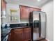 Kitchen featuring stainless steel refrigerator, granite countertops, and well-lit space with wooden cabinets at 8827 White Sage Loop, Lakewood Ranch, FL 34202