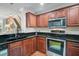 Well-equipped kitchen with stainless steel appliances, dark granite countertops, and wooden cabinets at 8827 White Sage Loop, Lakewood Ranch, FL 34202