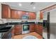 Modern kitchen featuring stainless steel appliances, granite counters, and warm wood cabinets at 8827 White Sage Loop, Lakewood Ranch, FL 34202