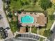 Aerial shot of a pool with lounging chairs, parking spaces, and lush landscaping at 8827 White Sage Loop, Lakewood Ranch, FL 34202