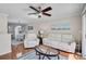 Bright and airy living room with hardwood floors, white leather sofa and fan at 8827 White Sage Loop, Lakewood Ranch, FL 34202