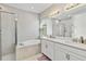 Bright bathroom featuring dual sinks, a soaking tub, and a tiled shower at 9061 Luna Ln, Sarasota, FL 34241