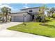 Charming two-story home with a well-manicured lawn, gray exterior, and a two-car garage at 9061 Luna Ln, Sarasota, FL 34241