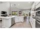 Open-concept kitchen with stainless steel appliances, quartz countertops, seamlessly integrated with living and dining area at 9061 Luna Ln, Sarasota, FL 34241